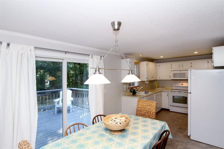 77 Sheffield Road Brewster, MA 02631 - Photo 7 of 26 a kitchen with stainless steel appliances wooden floor dining table and chairs