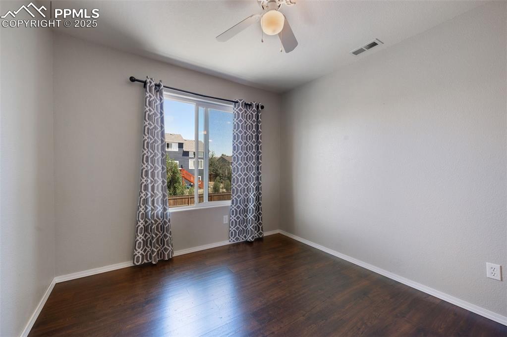 12206 Crystal Downs Road Peyton, CO 80831 - Photo 13 of 26 an empty room with wooden floor and windows