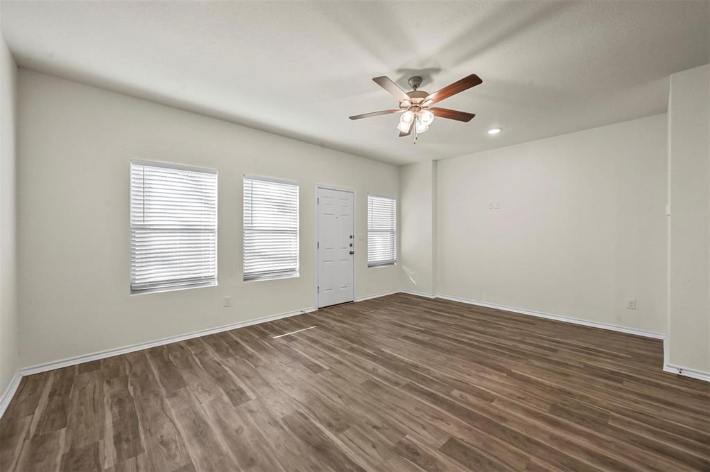 105 Southeast 4th Street, Unit 1 Kerens, TX 75144 - Photo 11 of 23 a view of an empty room with chandelier fan and wooden floor