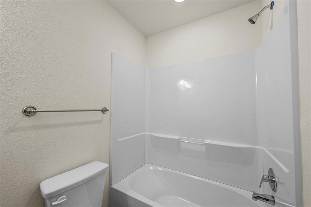 105 Southeast 4th Street, Unit 1 Kerens, TX 75144 - Photo 15 of 23 a white bath tub sitting next to a toilet