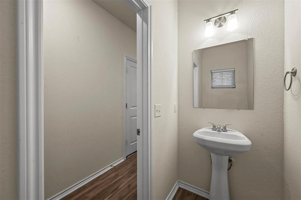 105 Southeast 4th Street, Unit 1 Kerens, TX 75144 - Photo 16 of 23 a bathroom with a sink a mirror and a shower