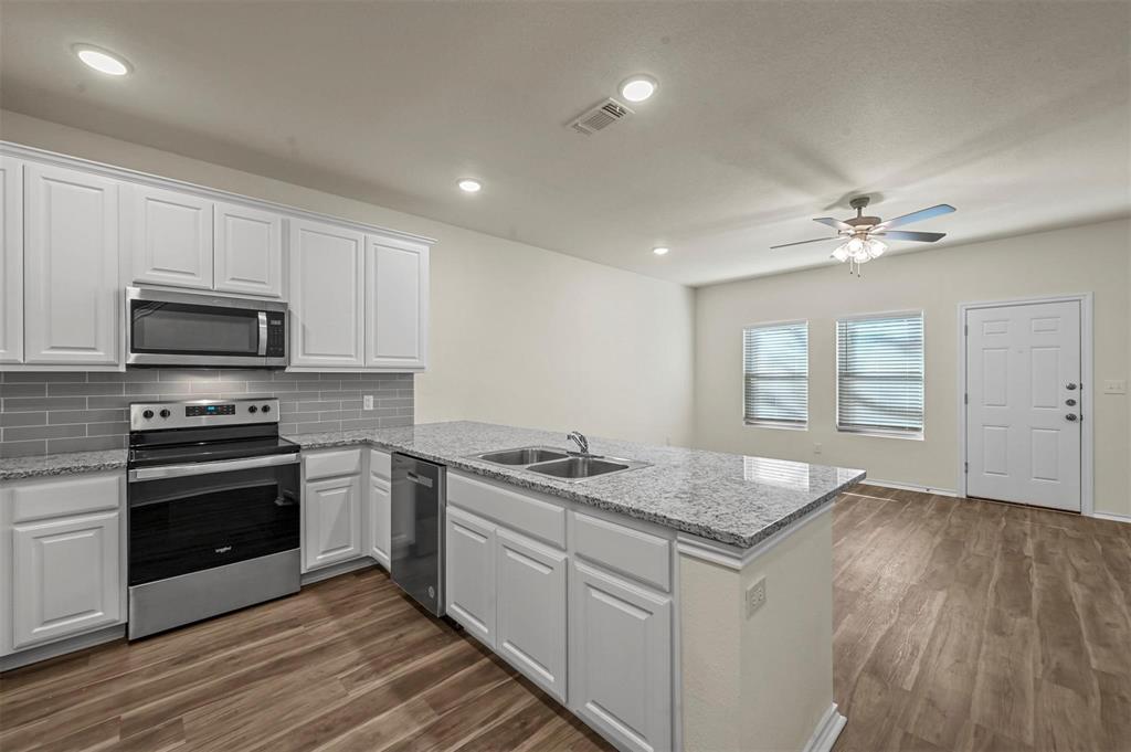 105 Southeast 4th Street, Unit 1 Kerens, TX 75144 - Photo 3 of 23 a kitchen with stainless steel appliances granite countertop a cabinets sink and stove top oven