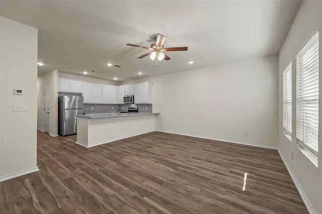 a view of kitchen with granite countertop cabinets and refrigerator