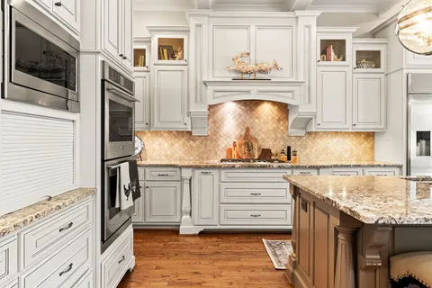 a kitchen with stainless steel appliances granite countertop a stove and cabinets