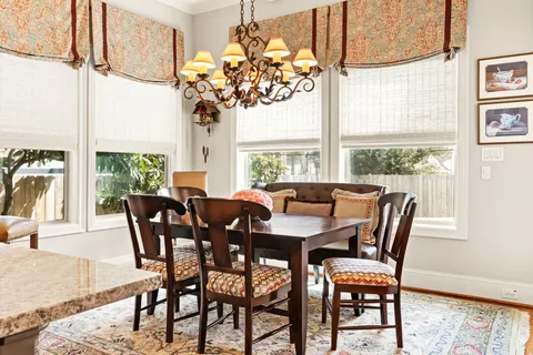 a view of a dining room with furniture a chandelier and wooden floor
