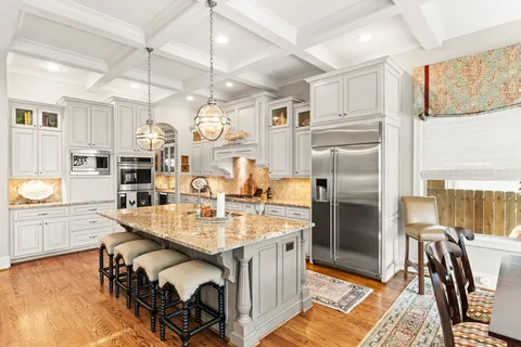 a kitchen with stainless steel appliances granite countertop a sink refrigerator and cabinets
