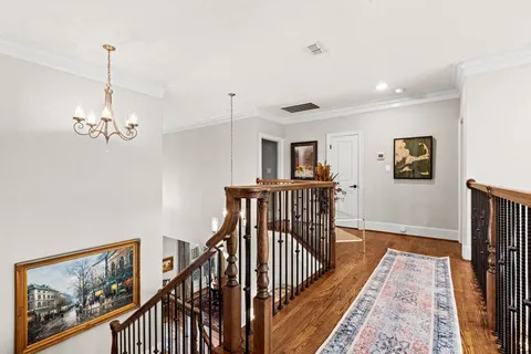a view of a hallway with wooden floor and staircase