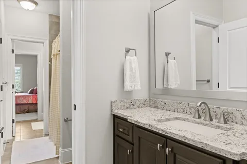 a bathroom with a granite countertop double vanity sink and a mirror