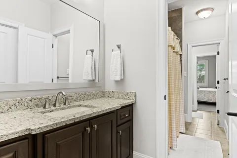 a bathroom with a granite countertop sink and a mirror
