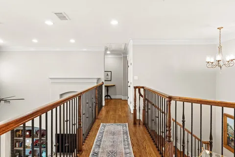 a view of a hallway with wooden floor and staircase