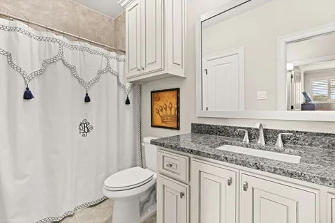 a bathroom with a granite countertop sink toilet and shower
