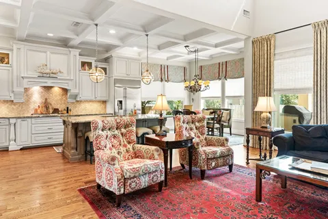 a living room with lots of furniture and a kitchen view