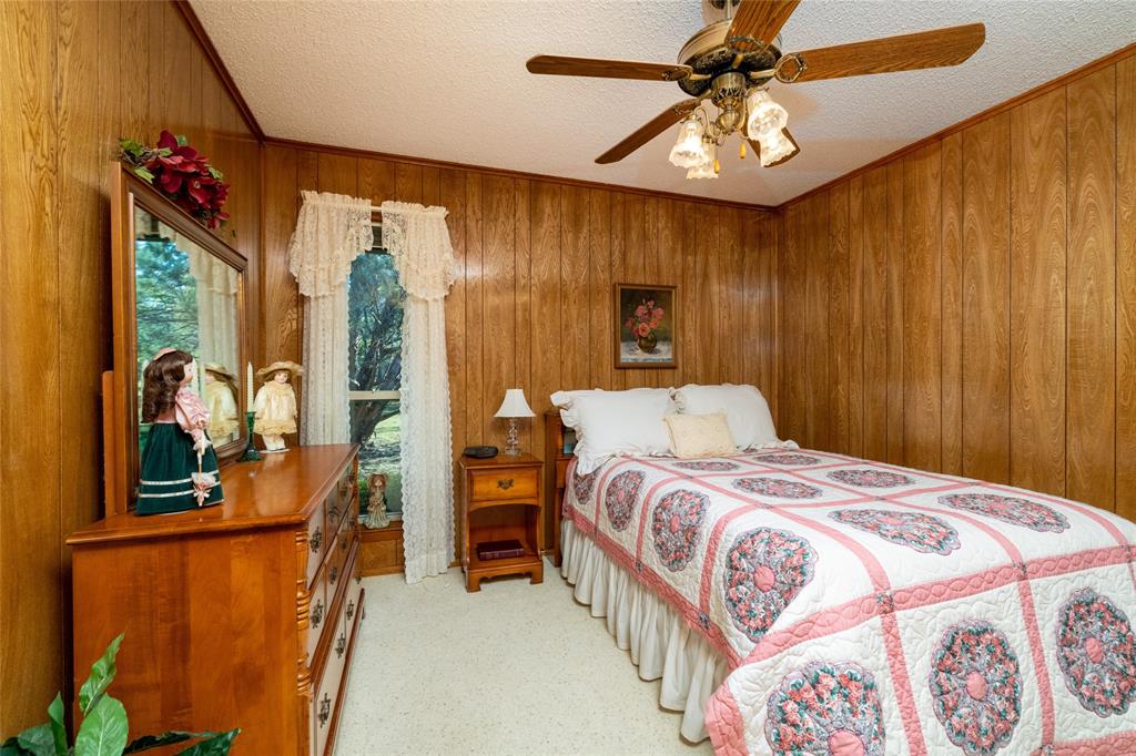 970 Live Oak Road Santo, TX 76472 - Photo 27 of 40 a bedroom with a bed and a chandelier