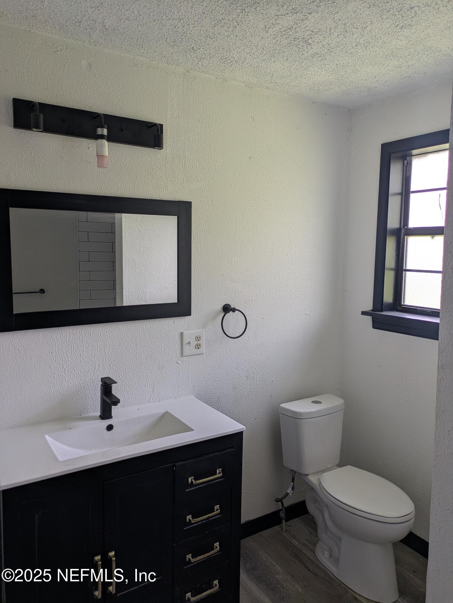 54559 Marlee Road Callahan, FL 32011 - Photo 26 of 33 a bathroom with a sink toilet and mirror