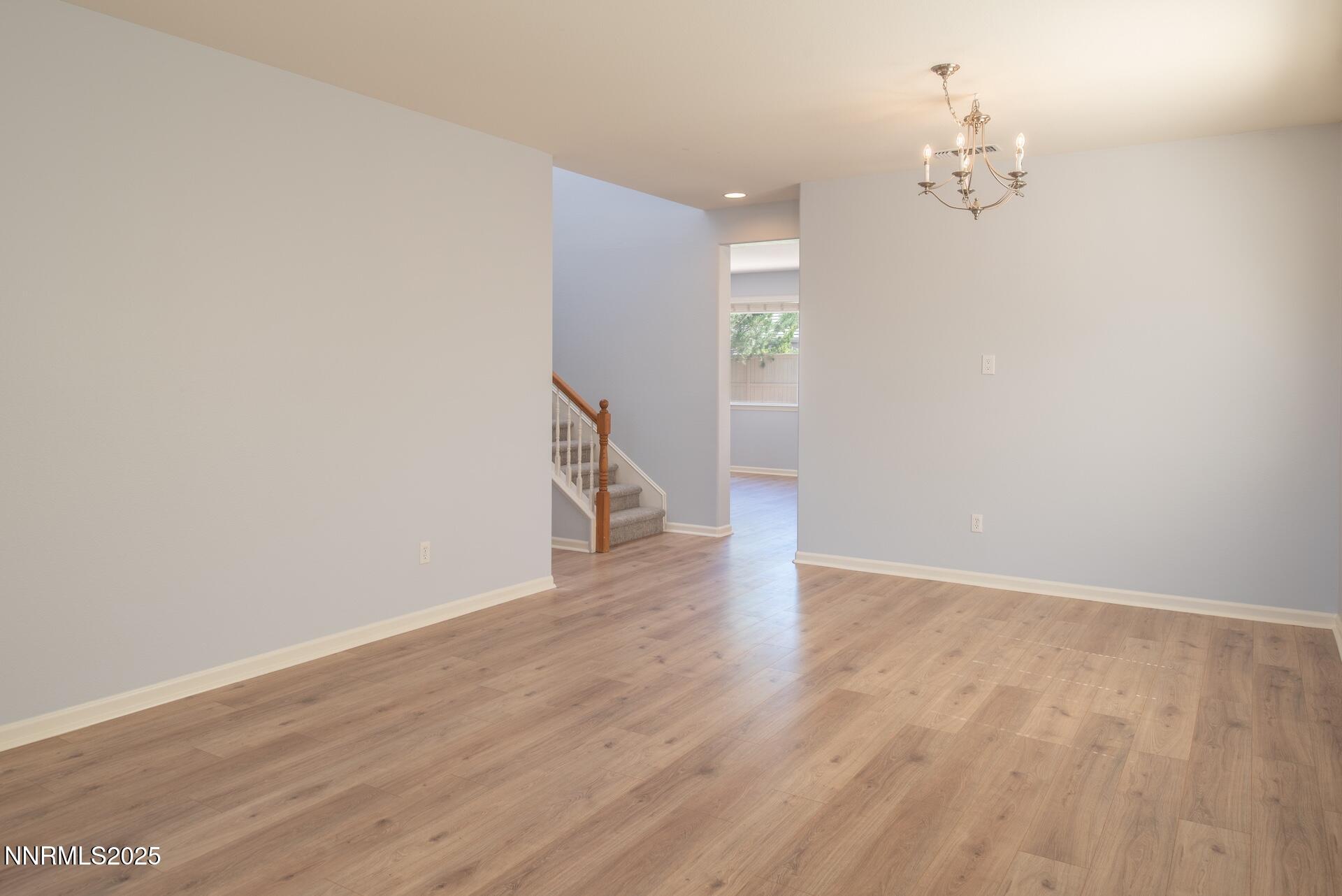 10630 Birch Point Court Reno, NV 89521 - Photo 4 of 42 a view of a hallway with wooden floor and a chandelier