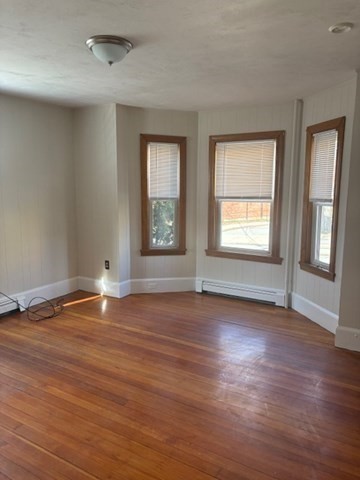 100 Prospect Street, Unit 1 Waltham, MA 02453 - Photo 7 of 12 an empty room with wooden floor and windows