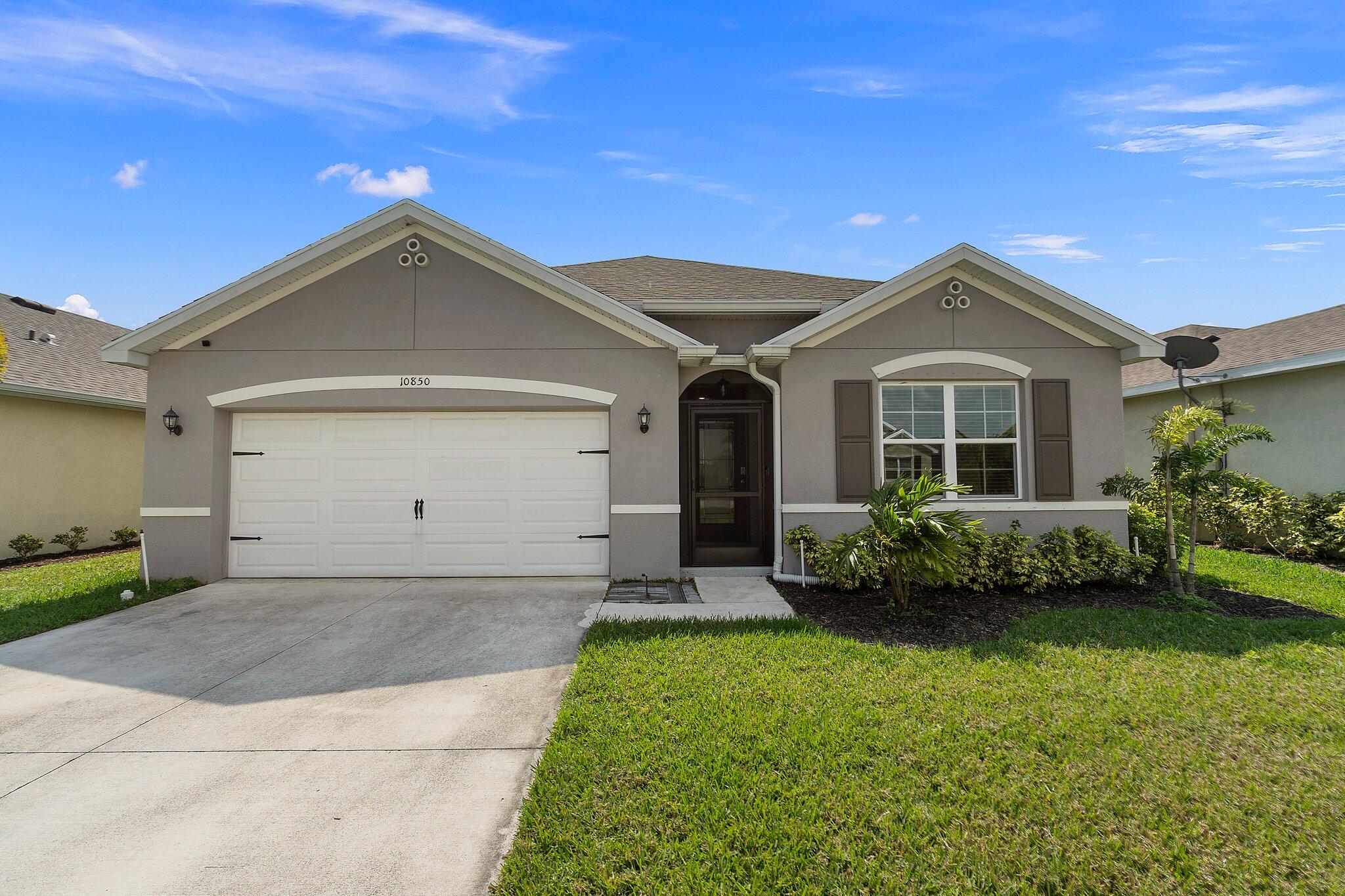 10850 Pacini Way Port St. Lucie, FL 34987 - Photo 1 of 36 a front view of a house with a garden