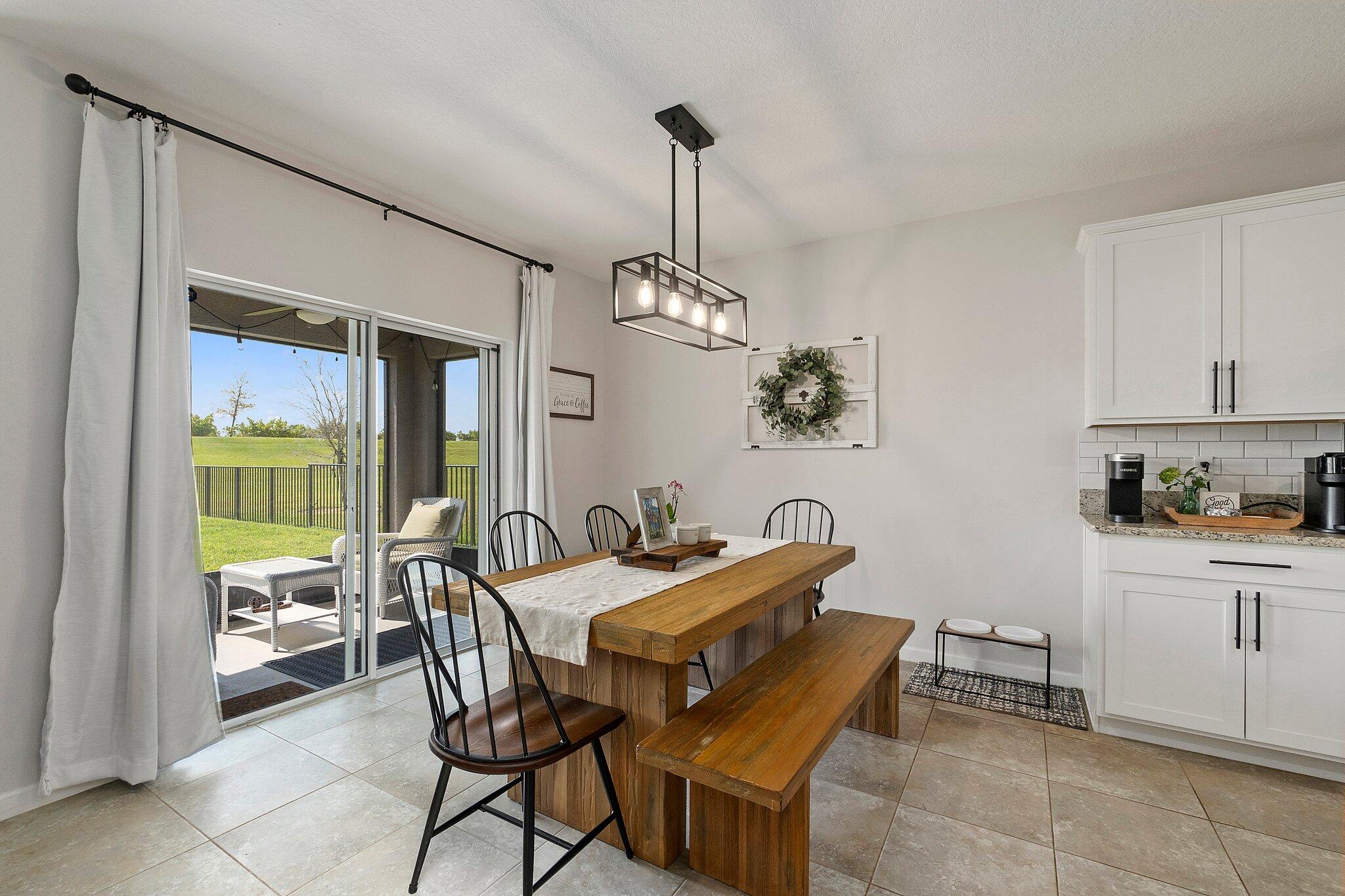 10850 Pacini Way Port St. Lucie, FL 34987 - Photo 12 of 36 a dining room with furniture a chandelier and wooden floor