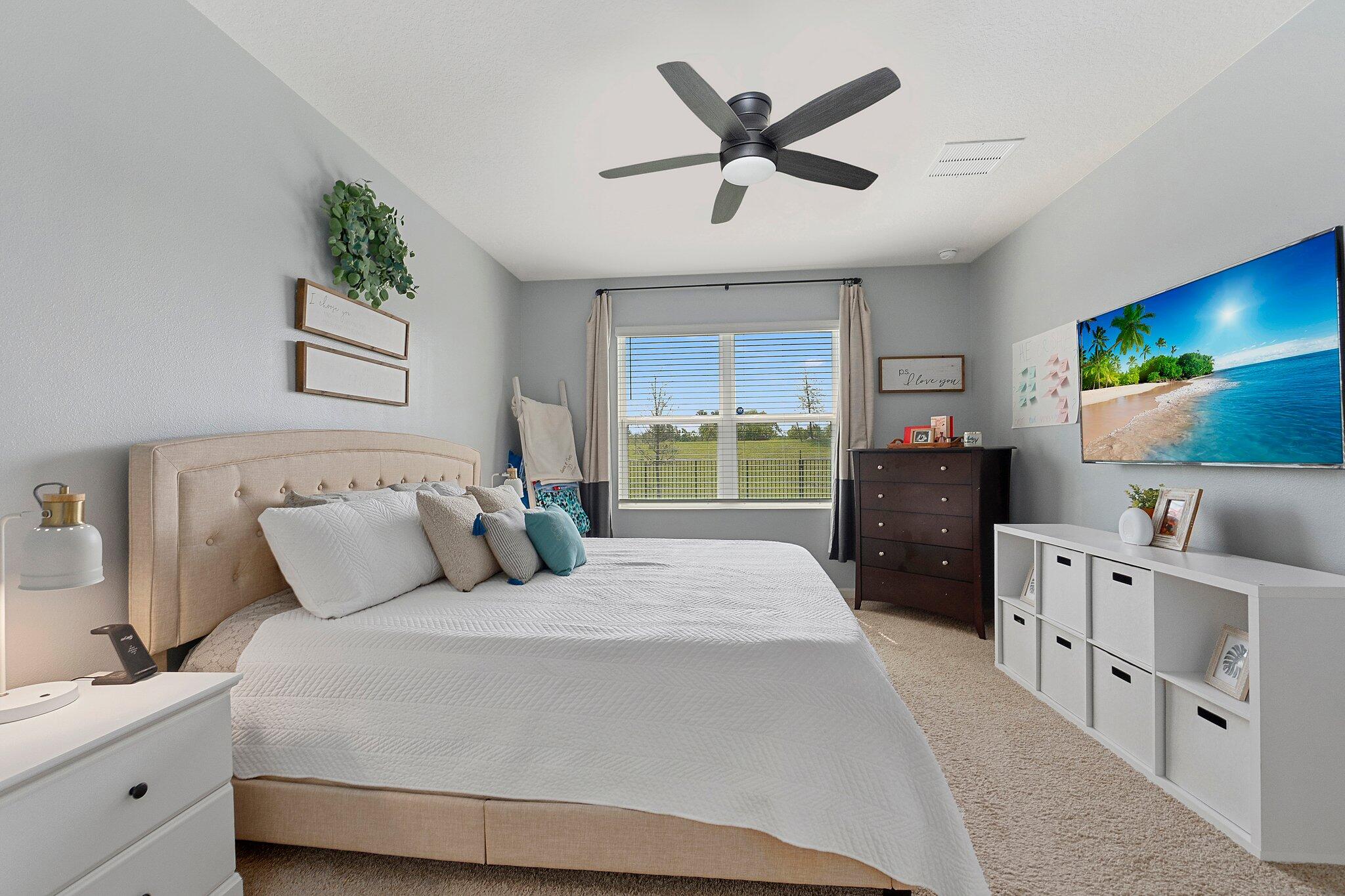 10850 Pacini Way Port St. Lucie, FL 34987 - Photo 16 of 36 a bedroom with a large bed and a flat tv screen on dresser