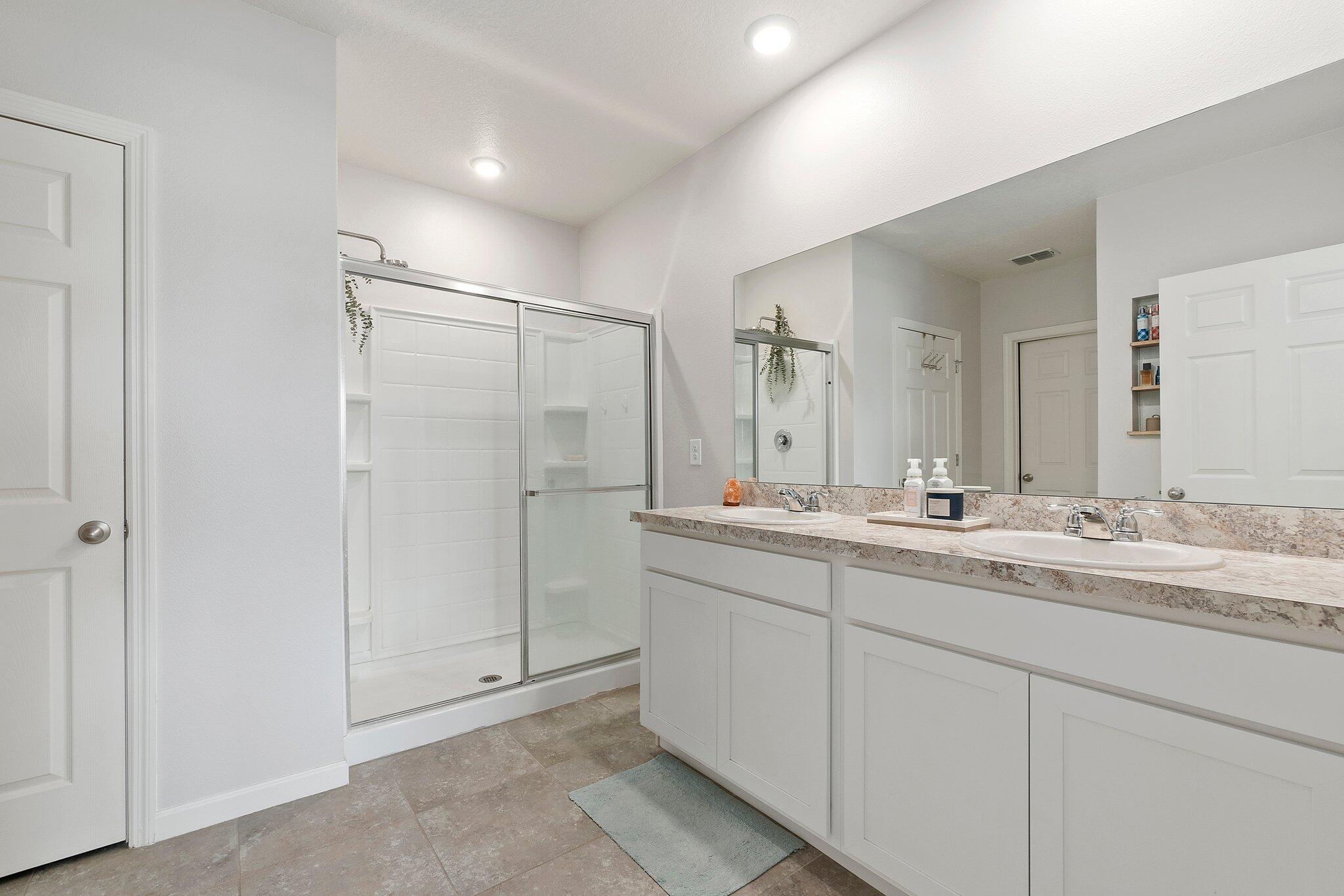 10850 Pacini Way Port St. Lucie, FL 34987 - Photo 17 of 36 a bathroom with a double vanity sink mirror and shower