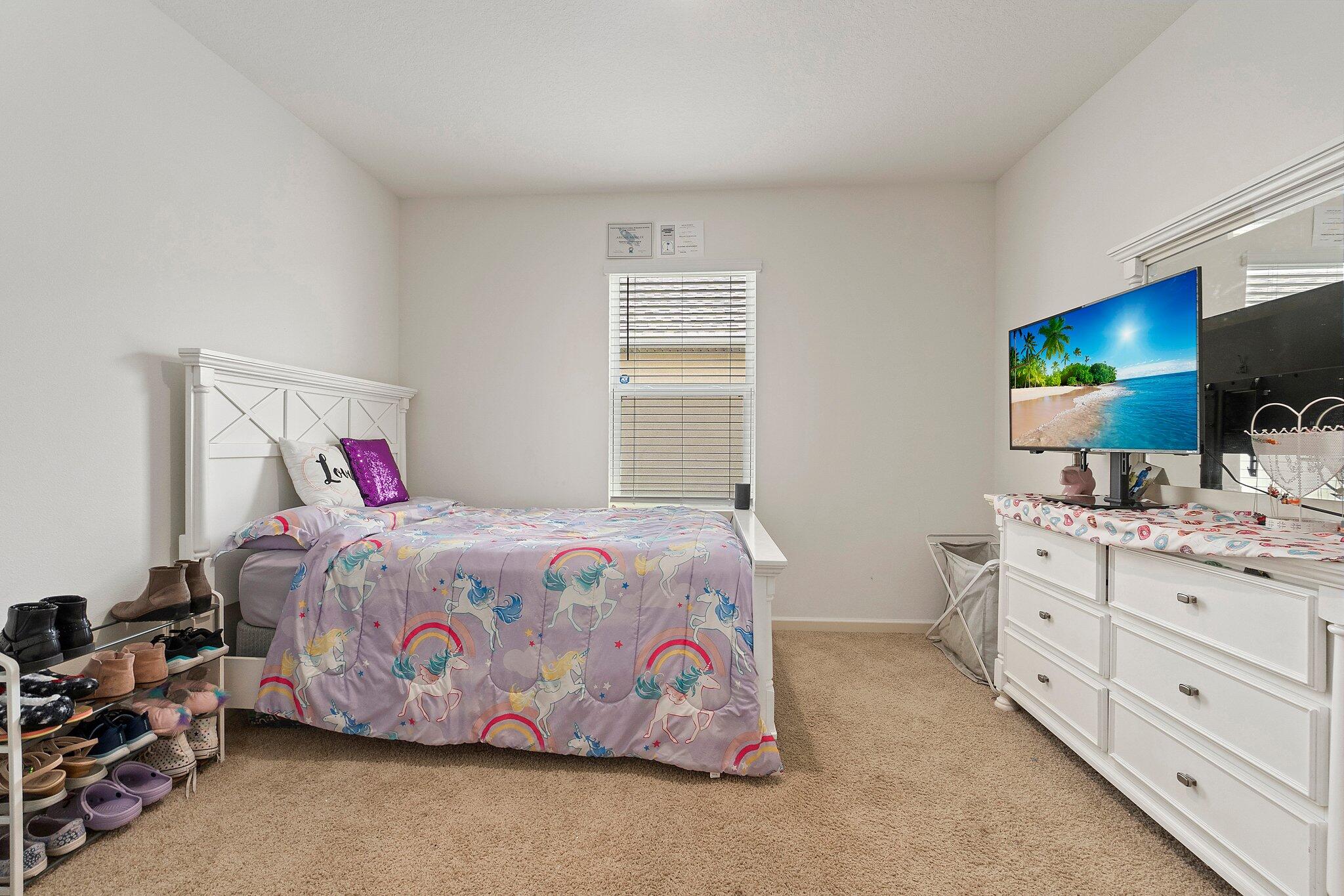 10850 Pacini Way Port St. Lucie, FL 34987 - Photo 23 of 36 a bedroom with a bed and a flat screen tv in it