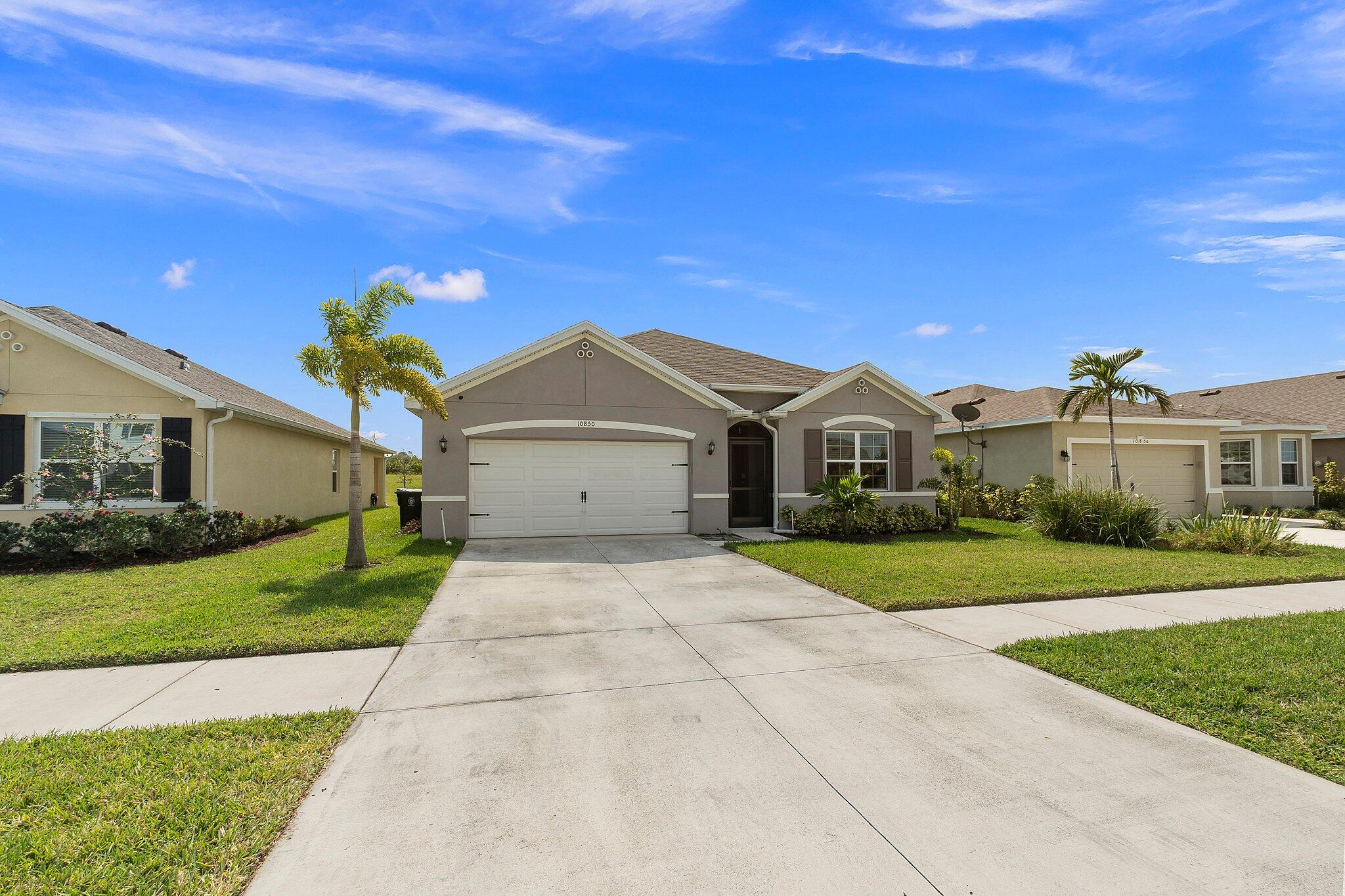 10850 Pacini Way Port St. Lucie, FL 34987 - Photo 34 of 36 a front view of a house with a yard and garage
