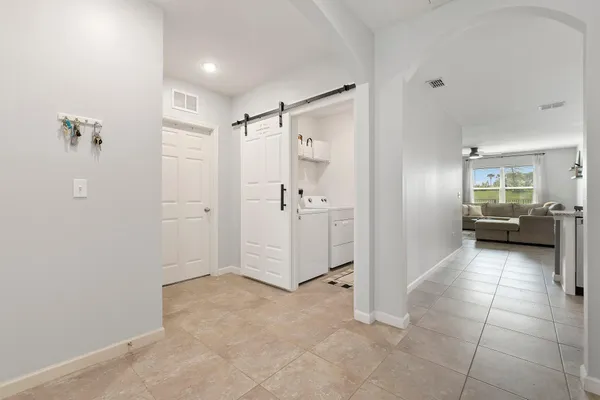 a kitchen with stainless steel appliances kitchen island granite countertop a stove a sink a refrigerator and white cabinets with wooden floor