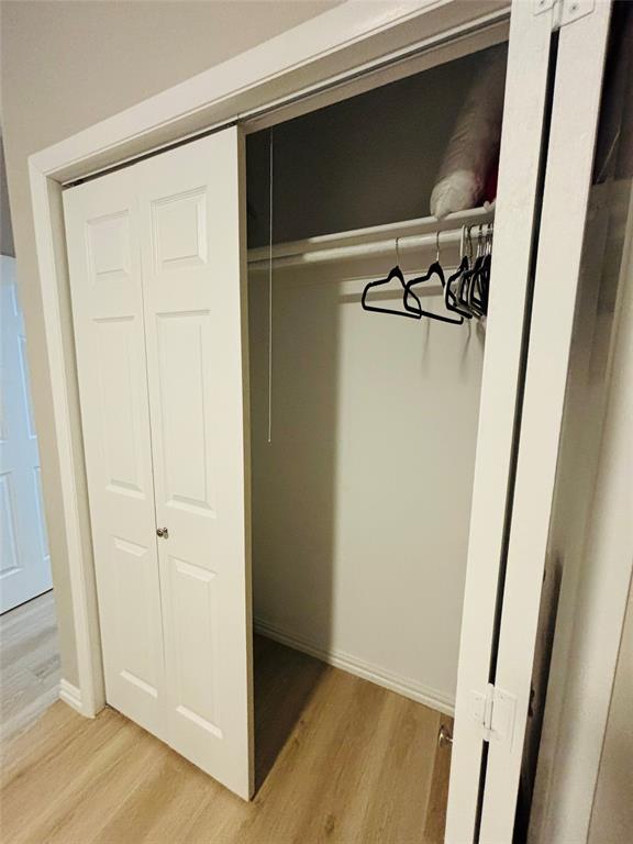 14277 Preston Road, Unit 416 Dallas, TX 75254 - Photo 17 of 40 Built-in closet with bi-fold doors, hanging rod, and light wood-finish flooring