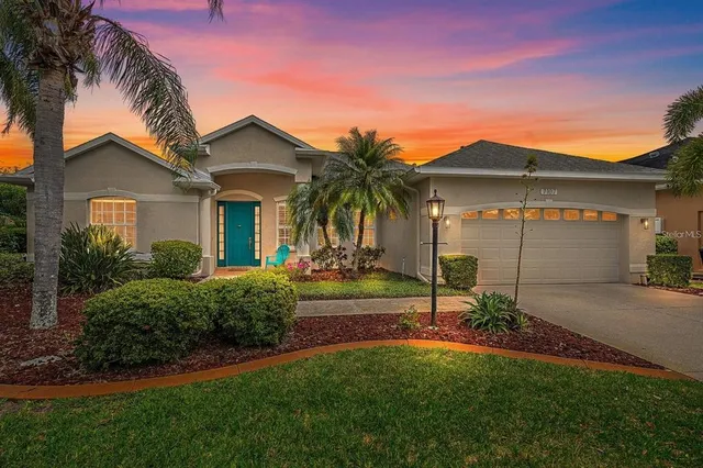 a view of a house with a yard and palm trees