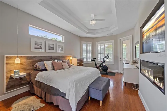 a spacious bedroom with a bed a couch and large windows