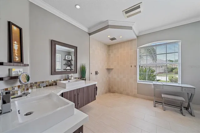 a bathroom with a double vanity sink bathtub and next to a window
