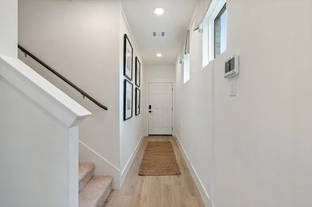 a view of a hallway with wooden floor and staircase