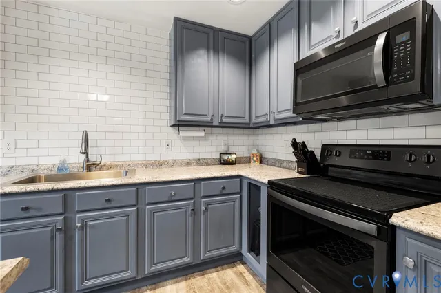 a kitchen with stainless steel appliances granite countertop a stove microwave and sink