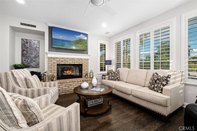 a living room with furniture a fireplace and a flat screen tv