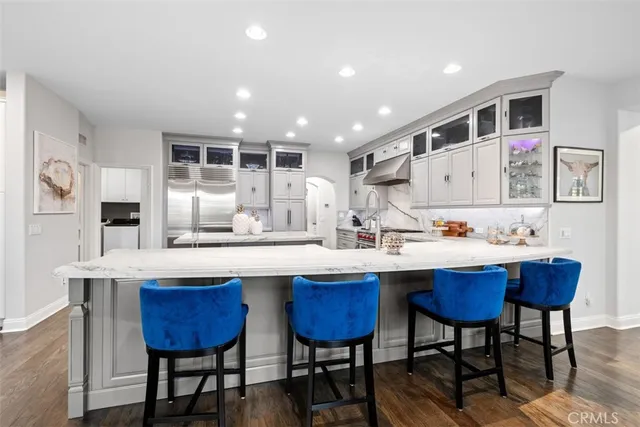 a kitchen with stainless steel appliances kitchen island granite countertop a table chairs sink and cabinets