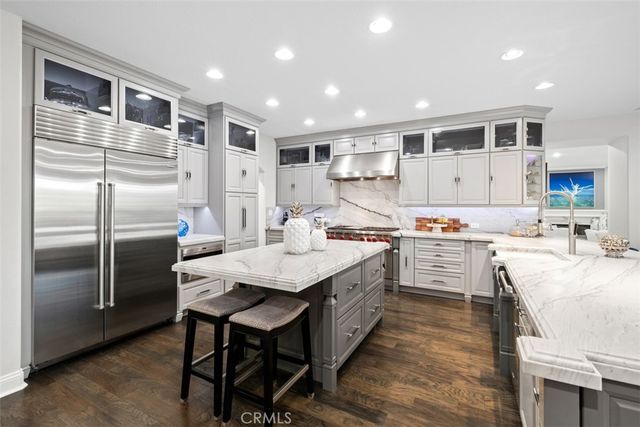 a kitchen with kitchen island granite countertop a sink appliances and cabinets