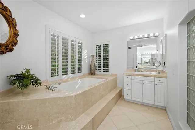 a spacious bathroom with a tub sink and mirror