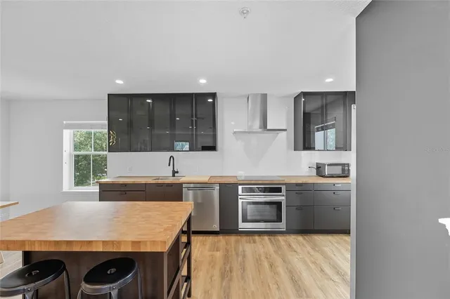 a kitchen with stainless steel appliances granite countertop a sink stove and refrigerator
