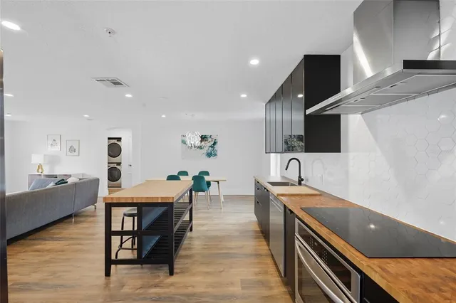 a kitchen with stainless steel appliances granite countertop a sink counter space and wooden floor