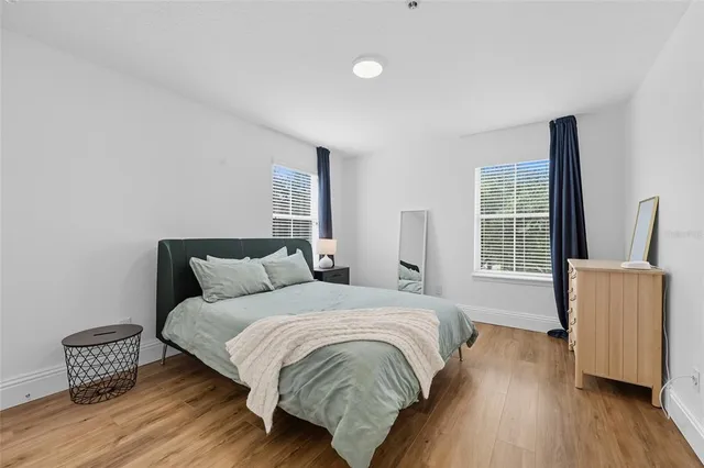 a bedroom with a bed and wooden floor