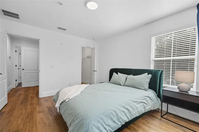 a bedroom with a bed and wooden floor