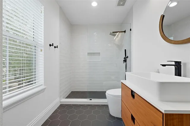 a bathroom with a sink a toilet and shower