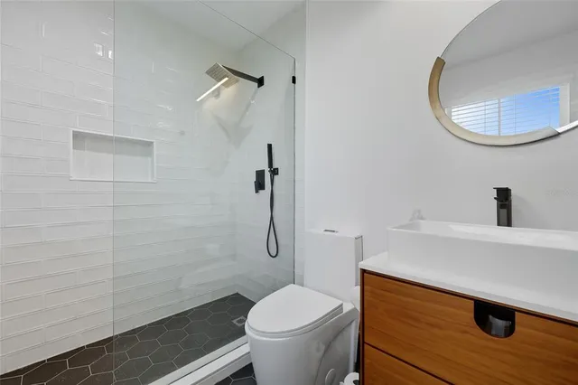 a bathroom with a sink a toilet and a mirror