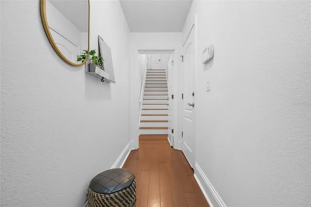 a view of hallway with stairs and wooden floor