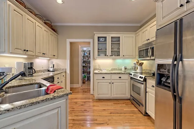 a kitchen with stainless steel appliances granite countertop a refrigerator sink and stove top oven