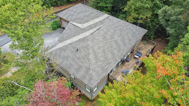 an aerial view of a house with a yard and large trees