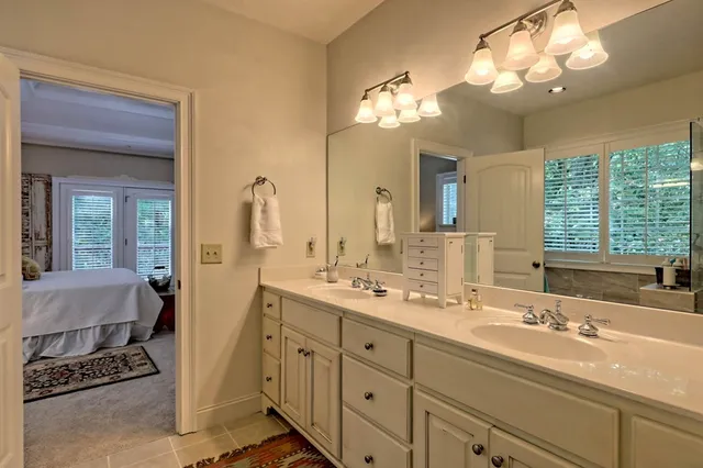 a bathroom with double vanity sink a mirror and a shower