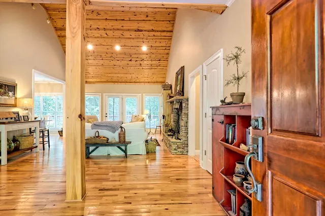 a living room with furniture large window and wooden floor