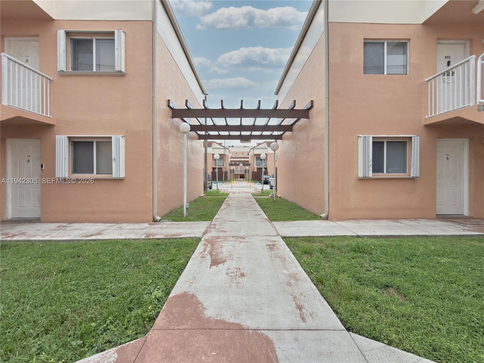 14911 Southwest 80th Street, Unit 221 Miami, FL 33193 - Photo 14 of 31 a front view of a house with a yard and garage