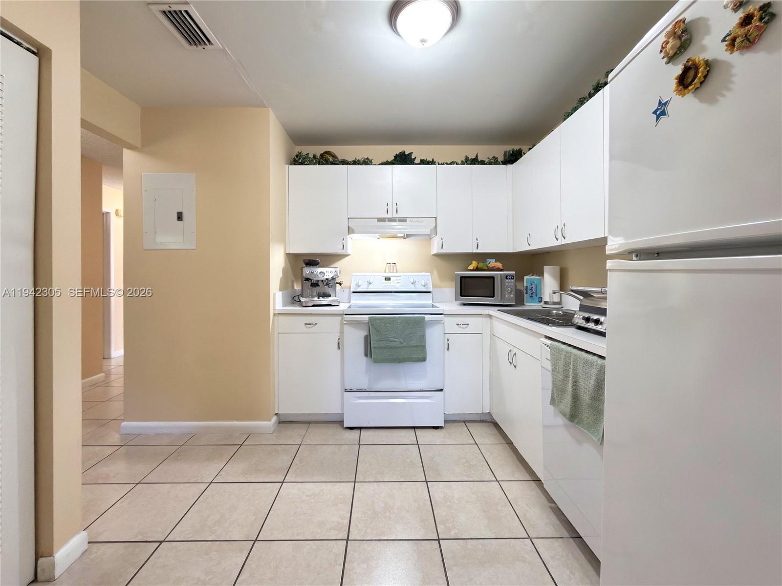 14911 Southwest 80th Street, Unit 221 Miami, FL 33193 - Photo 17 of 31 a kitchen with a stove top oven and cabinets